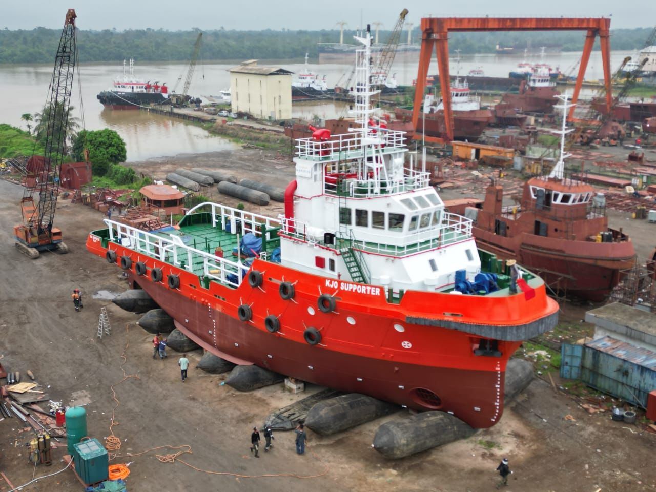 Orange and white tug supply vessel KJO Supporter on airbags in the shipyard